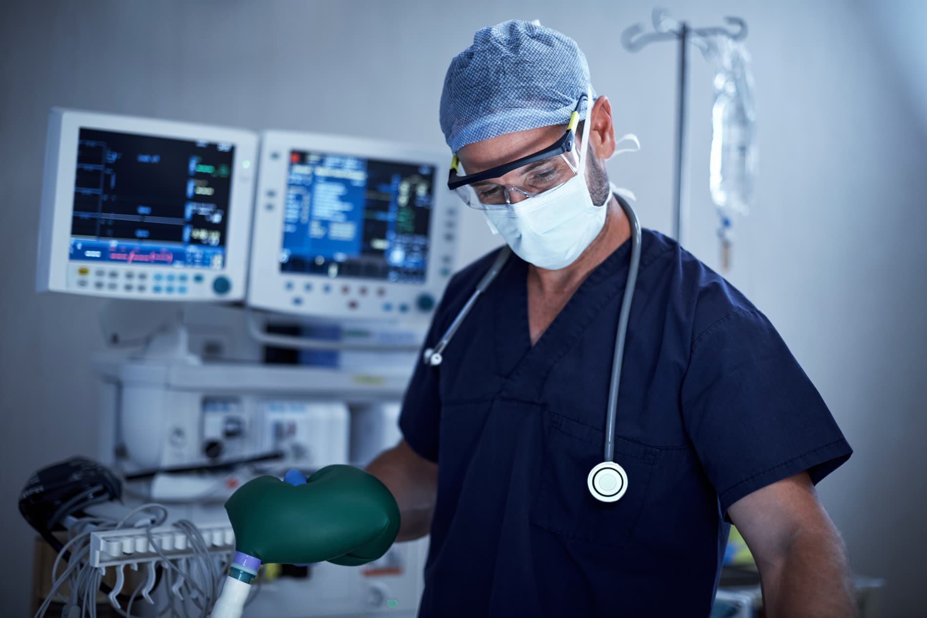 Médecin anesthésiste-réanimateur au bloc opératoire, devant les moniteurs de surveillance