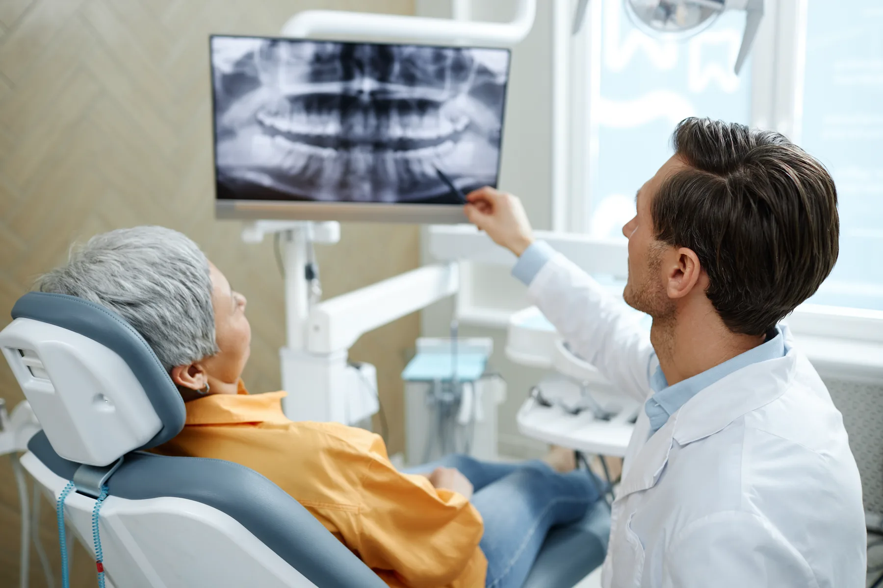 Chirurgien-dentiste analysant une radiographie panoramique dentaire